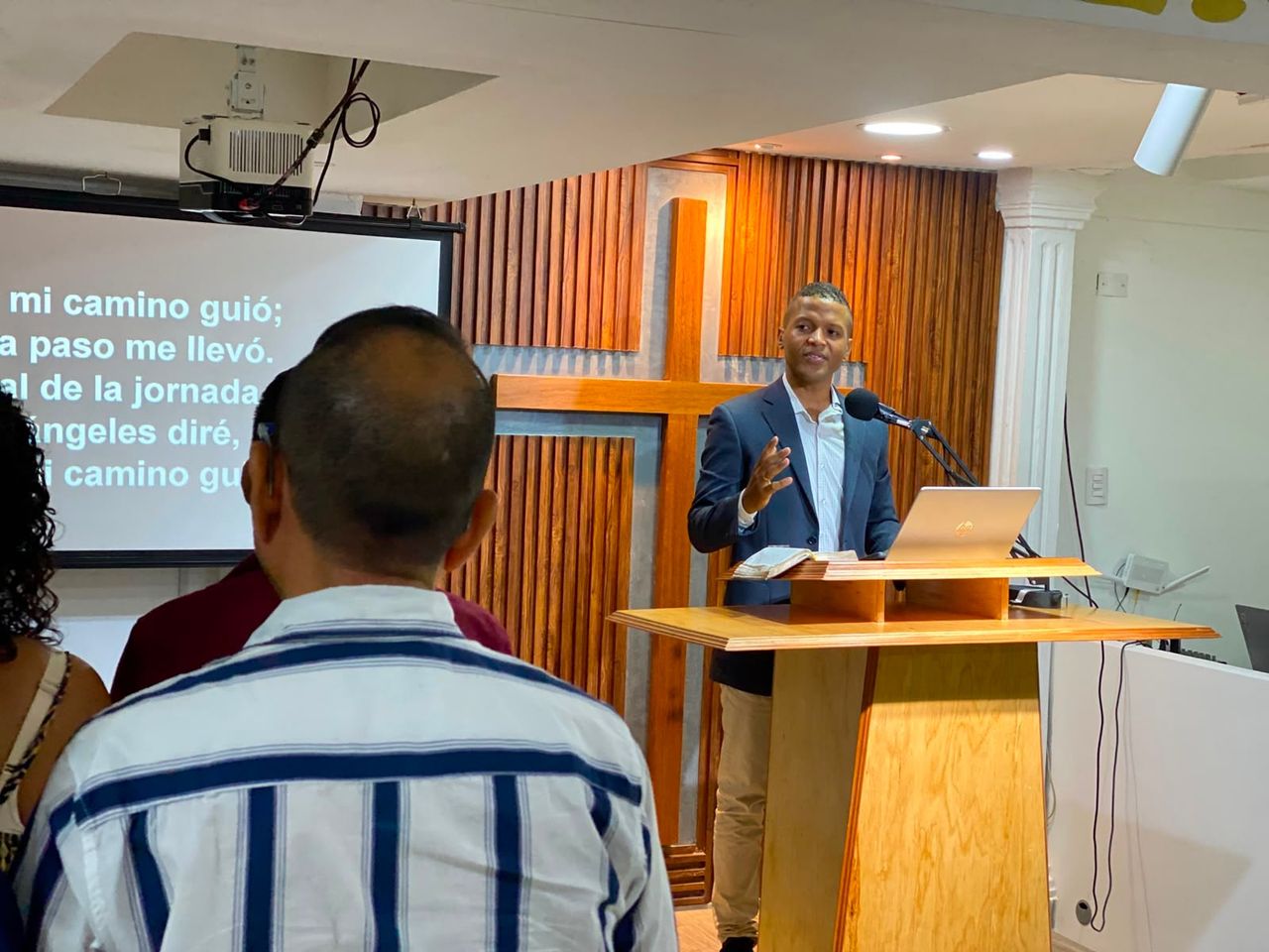 Vista de la iglesia — predicador, púlpito, cruz y congregación